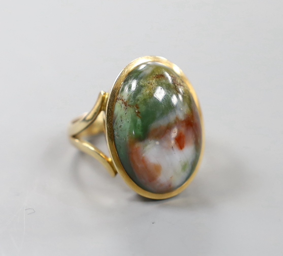 A yellow metal and cabochon polychrome agate? set oval ring, with engraved inscription to the shank, size O, gross weight 10.6 grams.